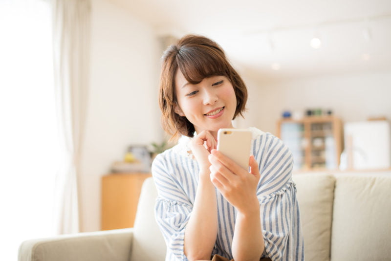 借りやすいカードローン-家でスマホをいじる女性